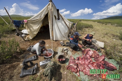 The law of the camp: the meat is shared among everybody. Omak Baraan, Roman Baraan and Oksana Duganchi dividing the carcass.